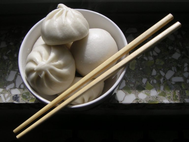 Steamed buns filled with sauce and meat with chopsticks